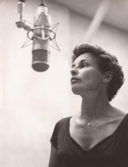 A photo of Bonnie Prudden speaking into a microphone.