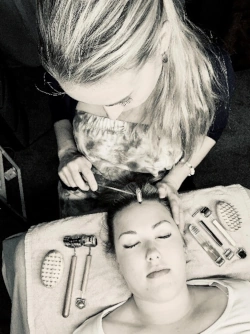 Aimee Sebastian performing facial reflexology on a client