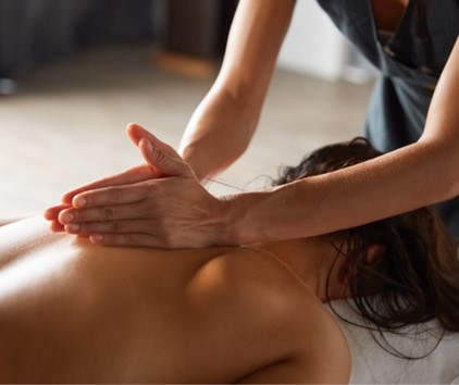 A person having their back massaged with the sides of a practitioner's hands.