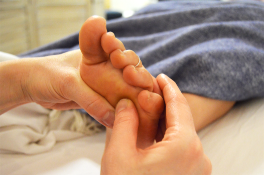 Close-up of foot reflexology being administered
