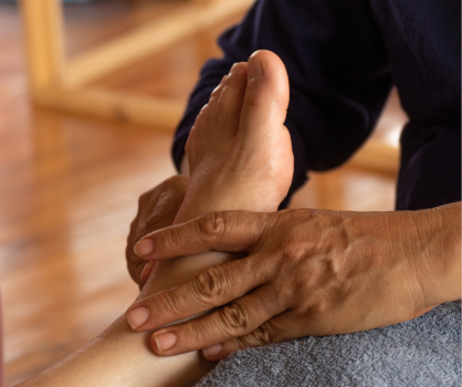 Massage therapist treating a client's foot