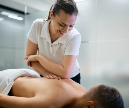 A massage therapist working on their client's back with her elbow. 