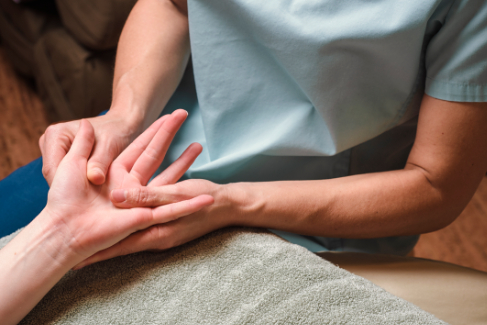NHPC Reflexology practitioner performing hand massage