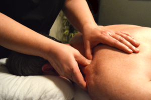 A massage therapist treats a client's shoulder