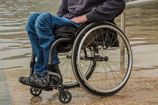 A person in a wheelchair beside water. 