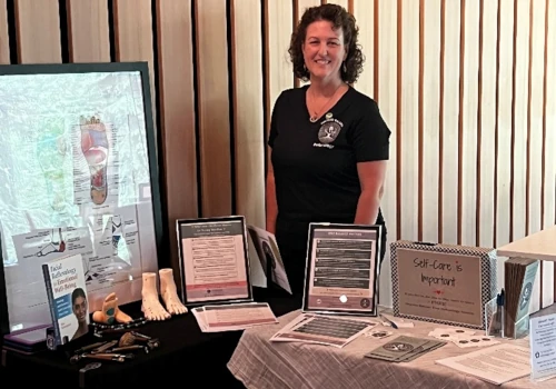 Sarah Dykstra behind a table with an exhibit of her practice
