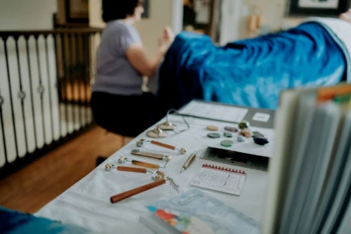 Reflexology tools arranged on a table with Sarah Dykstra working in the background