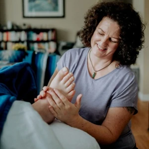 Front view of Sarah Dykstra working on a client's foot