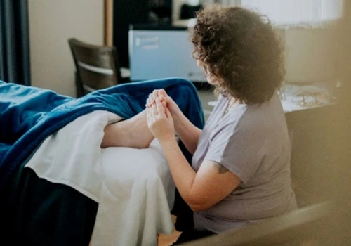 Side view of Sarah Dykstra working on a client's foot. 