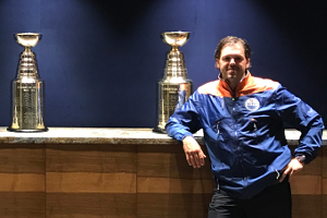 Stephen Lines standing beside a row of Stanley Cups