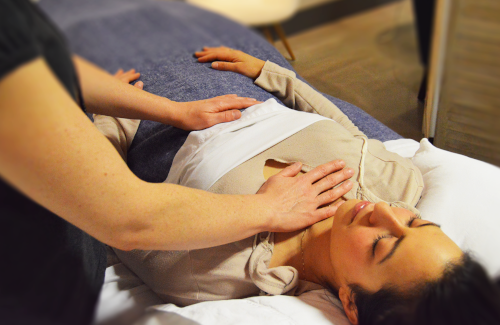 Therapeutic touch being practised on a prone client.