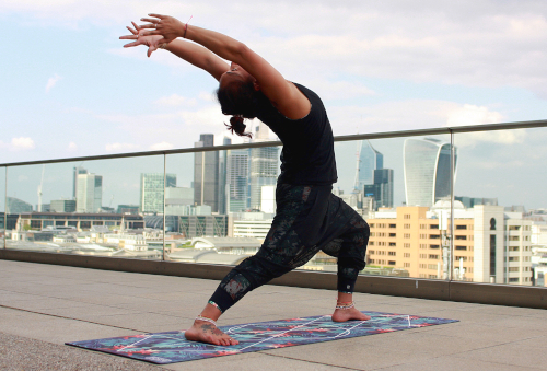 Yoga back bend on a terrace overlooking a city. 